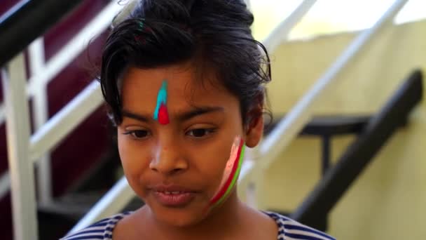 Malá asijská dívka slaví barevný festival. Teen věk dívka stříkající barvu na tvář a těší barevný festival v Indii. Color festival v Indii 2021 koncept. — Stock video