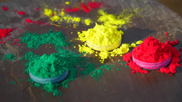 Splashing colors heap on floor. Color spreading on ground. Organic Kumkum color in plastic can with herbal color dye.