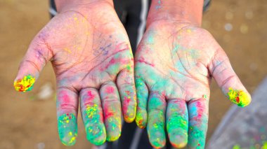 Gökkuşağı renkli tozlarla insan eline odaklan. Holi renk tozlarıyla el..