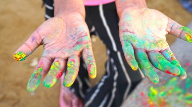 El holi renkleri çalıyor. İnsan elinde Rangoli renkleri. Mutlu Holi ve Dhulandi 2021 Özel.