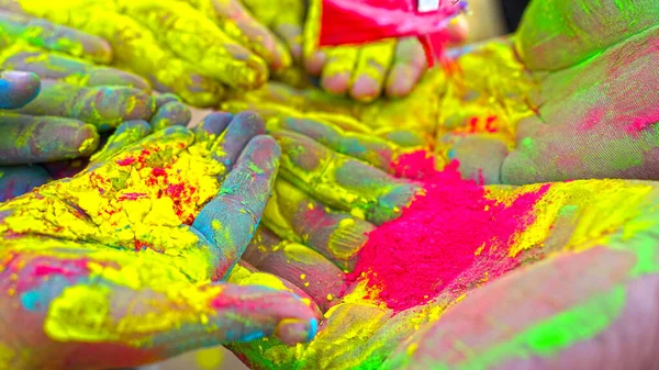 Child\'s hand painted with Gulal color join each other. Kid hand playing Holi with vibrant colors.