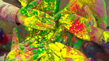 Sarı, Kırmızı ve Yeşil Holi festivalinin renkleriyle kaplı genç insanların elleri ya da palmiyeleri. Holi kutlamaları.