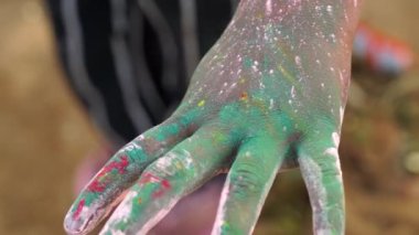 Footage of Holi colors on human hand. Little kid enjoying Holi or Dhulandi festival with herbal Gulaal.