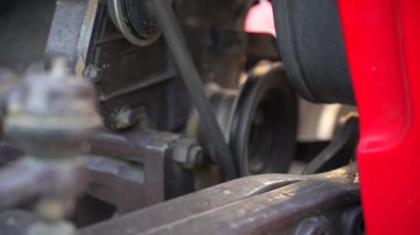 Motor alternatörü ve vantilatör kayışı dönüş hızında hareket ediyor. Eski rustik araba kemeri veya alternatör görüntüsü.
