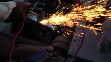 Sanayi adamı fabrikada çalışıyor, ağır makine parçalarını öğütüyor. Ağır üretim endüstrisi konsepti.