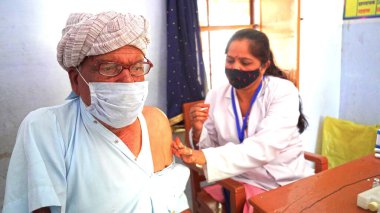 08 Nisan 2021 - Akhepura, Sikar, Hindistan. Antiviral enjeksiyondan önce ellerin şırıngayı tutması ve üst koldaki deriyi temizlemesi gerekiyor. Kapak aşısı kavramı.