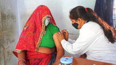 08 Nisan 2021 - Akhepura, Sikar, Hindistan. Covid 19 ya da Coronavirus aşısı yapmadan önce elinde şırınga tutan hemşire. Covid 19 aşısı ve Hindistan 'da ikinci dalga etkisi.