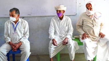 08 Nisan 2021 - Akhepura, Sikar, Hindistan. İnsanlar yerel bir sağlık merkezinde ilk Covid 19 koronavirüs aşısını almak için sıralarını bekliyorlar..