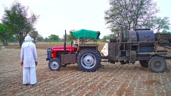 脱穀機トラクターと穀物収穫。農業分野での脱穀機の閉鎖を持つトラクター. — ストック写真