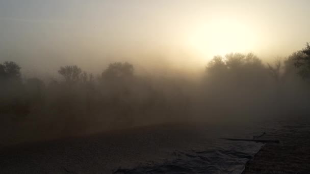 Pšeničná nebo žitná sláma a prach foukání v zemědělství farma s západem slunce pozadí. — Stock video