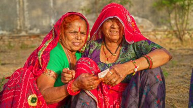 15 Nisan 2021 - Reengus, Sikar, Hindistan. İki yaşlı kadının Covid 19 sırasında birbirlerine para verirken ön planda çekilmiş. Hindistan 'da covid 19 sırasında ekonomik kriz.