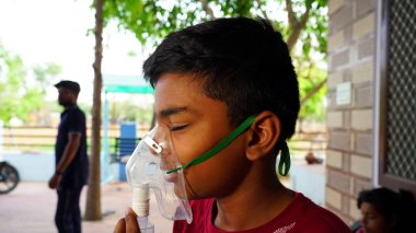 Çocuk yüzüne Oxygen Cannula 'yı ayarlıyor. Çocuk SARS Covid virüsünden çok acı çekiyor. Corona, Hindistan kavramında ölümcül etki yarattı.