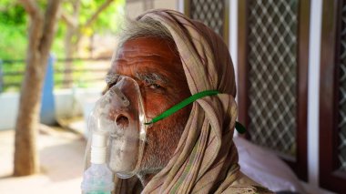 30 Nisan 2021, Jaipur, Rajasthan, Hindistan. Covid ikinci dalga, Hintli hasta dışarıda bir hastanede oturuyor. Hastaneler dolu ve oksijen eksikliği çekiyorlar..