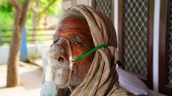 30 Nisan 2021, Jaipur, Rajasthan, Hindistan. Covid ikinci dalga, Hintli hasta dışarıda bir hastanede oturuyor. Hastaneler dolu ve oksijen eksikliği çekiyorlar..