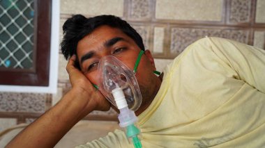 Genç Hintli hastanenin dışında Cannula ile acil durum oksijeni alıyor. Hindistan 'daki Covid kavramına bağlı ciddi nedenler.