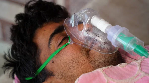 Genç Hintli çiftçi Cannula ile acil durum oksijeni alıyor. Hindistan 'daki Covid kavramına bağlı ciddi nedenler.