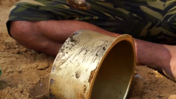 Indian man trying to clean  old brass pot with pure clay in outdoor. 4k HQ footage — Stockvideo