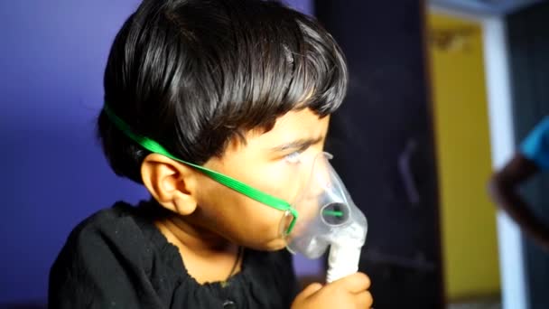 Roztomilá indická dívka s kyslíkovou maskou, dívá se ven smutnýma očima. Corona virus třetí vlny v Indii. — Stock video