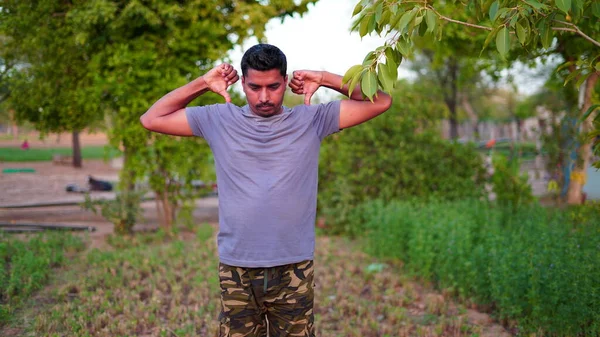 Sağlıklı bir adam parkta yeşil çimenler üzerinde egzersiz yapıyor. Yoga günü konsepti