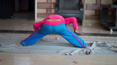 Indian little boy exercising at home. Family working out at home. Worldwide yoga day concept.