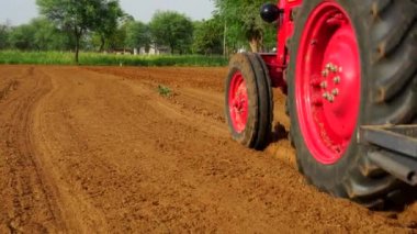 Tohum ekmek için boş bir araziden geçen traktör. Tarım ve sulama kavramı.