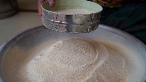 Hintli bir kadın ekmek pişirmek için buğday unu karıştırıyor. Kadın unu süzgeçten geçirir.. — Stok video