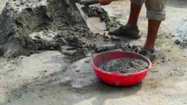 Profesyonel inşaat işçisi ıslak gri çimentoyu karıştırır. 4k video klibi