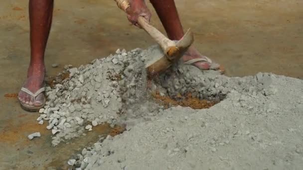 Sokaklarda beton karışımı oluşturun. Kum ve çimentoyu küçük bir inşaat projesi için kürekle karıştıran bir erkek işçi.. — Stok video