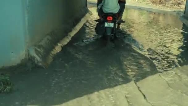 Bred vinkel skott av motorcykel in och ut ur en gångtunnel under dagtid — Stockvideo