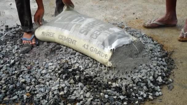 Arbeiter gießen die richtige Menge Zement in die Betonmischung und mischen weiter in den Straßen mit Schaufeln. — Stockvideo