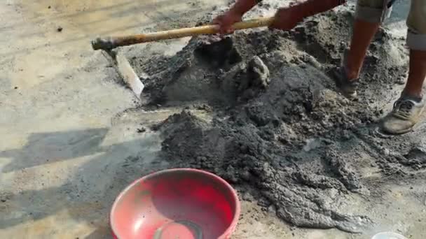 Gießen Sie die richtige Menge Wasser in die Betonmischung und mischen Sie weiter in den Straßen mit Schaufeln. — Stockvideo