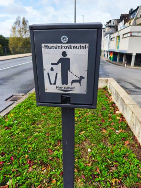 ISERLOHN, ALMANLIK 13 Ekim 2025: Penny süpermarketinin park yerinde korunan kırmızı el arabası 