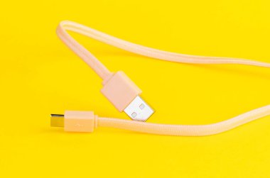 Sarı arka planı olan bir USB kablosunun yakın plan görüntüsü teknoloji ve tasarım kavramları için mükemmeldir.
