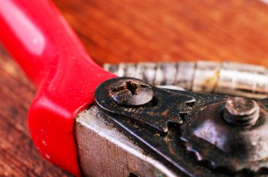 Eski paslı budama makası, paslanma, paslanmış metal ve desenli yüzey üzerindeki vidanın yakın çekim makro fotoğrafı. Bahçe işleri, aletler ve endüstriyel kavramlar için ideal..