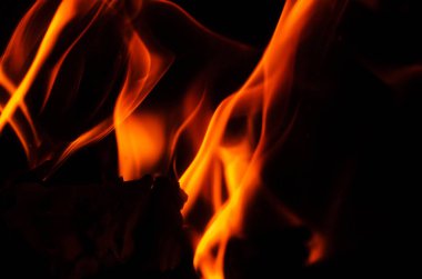 Parlak turuncu ve sarı alevler siyah ile keskin bir tezat oluşturarak dramatik ve büyüleyici bir görsel yaratıyor.