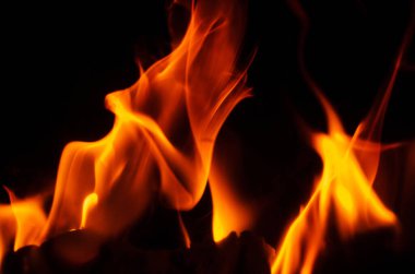 Parlak turuncu ve sarı alevler büyüleyici bir ışık ve hareket gösterisi yaratır.