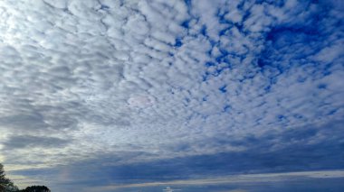 Kabarık bulutlar mavi gökyüzüne karşı güzel bir desen oluşturuyor, arka plan veya duvar kağıdı için mükemmel.