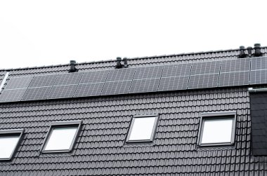 Modern evde güneş panelleri ve tavan pencereleri, çevre dostu tasarım ve yenilenebilir enerji çözümleri sergileniyor