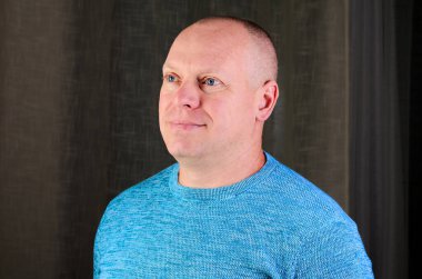 Mavi gözlü, orta yaşlı bir adamın portresi.