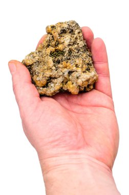 Beyazlara karşı kaba, doğal mineral numunesi tutan bir el.