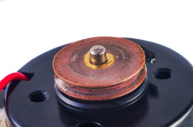 Siyah motor tabanındaki paslı, katmanlı makara mekanizmasının detaylı görüntüsü mekanik aşınma ve yırtılmaya işaret ediyor.