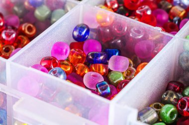 Organize zanaat deposunda çeşitli renkli cam boncuklar.