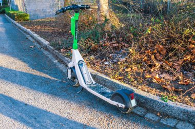 Gündüz vakti Almanya 'da şehir sokağına park etmiş elektrikli scooter ve modern sürdürülebilir ulaşım kavramı.