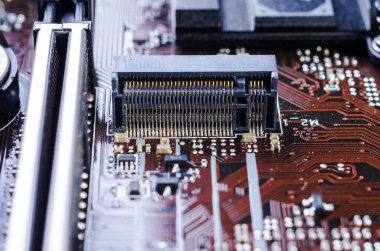 Bilgisayarın ana kartındaki karmaşık devreli bir M.2 yuvası bağlantısına yakın çekim.