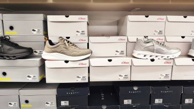 ISERLOHN, GERMANY 23 HAZİRAN 2026: Ayakkabı ve perakende ürünlerinin altını çizerek mağazada sergilenen Sprit terlikleri