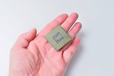 Bir insanın elindeki bilgisayar işlemci çipinin beyaz arka plana yakın plan görüntüsü