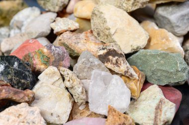 Kaba, cilalanmamış doğal taşlar ve minerallerden oluşan çeşitli bir koleksiyonun yakın görüntüsü