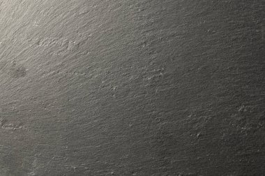 Kabataslak dokusunu ve ince ton ve ışık değişimleriyle katmanlı bileşimini gösteren doğal bir levha yüzeyinin detaylı bir görüntüsü