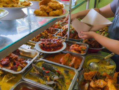 Garson Endonezya büfesinde garsonluk yapıyor.