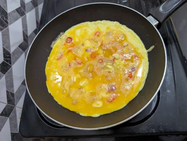 Sıcak tavada kızartılmış taze sebzeli leziz omlet.